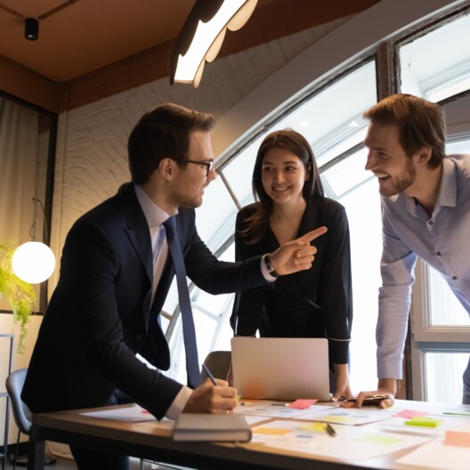 Excited multiracial diverse colleagues have fun brainstorming discussing business ideas at team meeting in office, happy multiethnic employees smile working together at briefing.