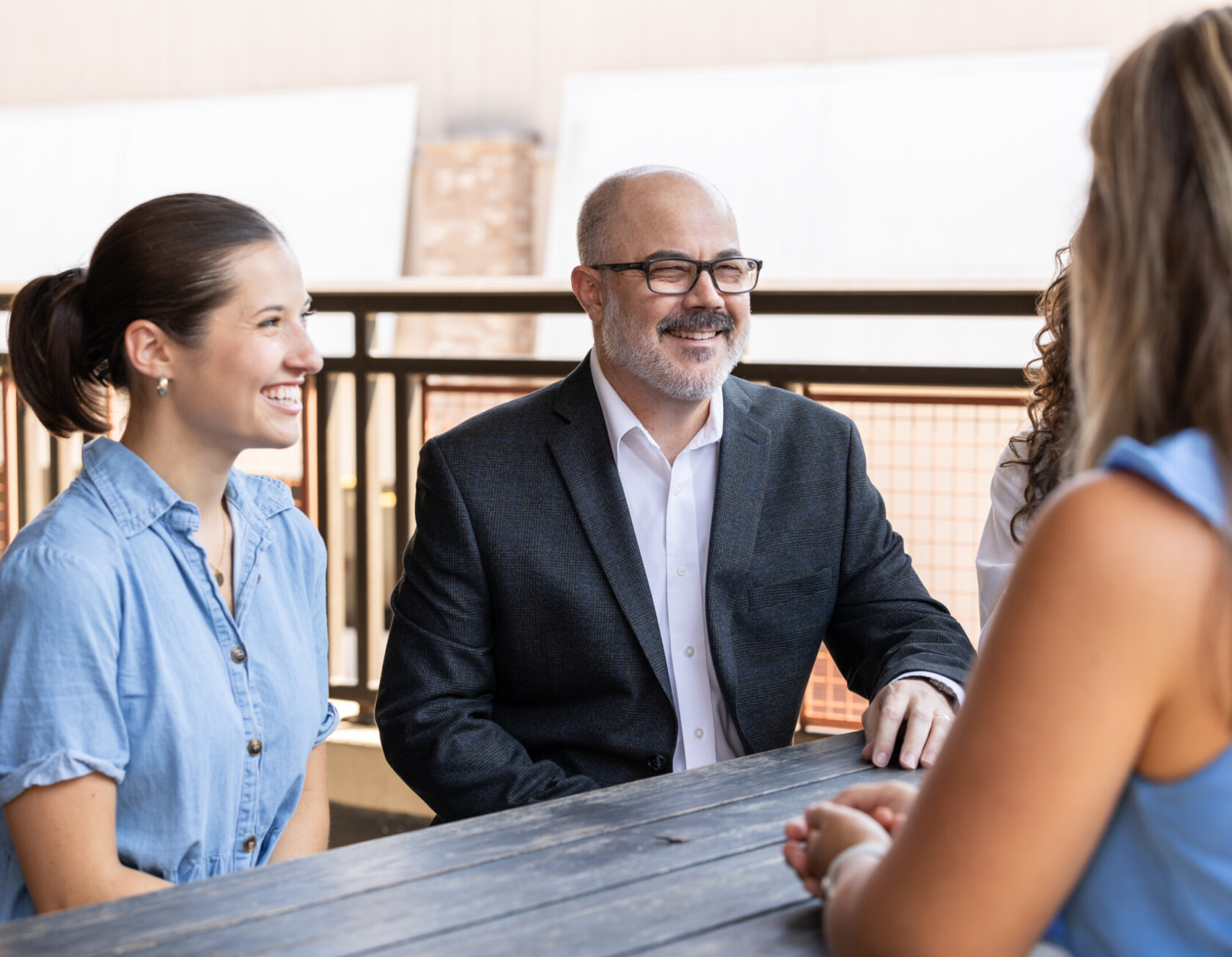 Group of Cmiforex employees brainstorming together at a table outside.